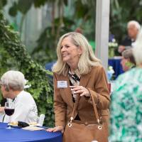 Vonnie Herrera standing with hand on table, smiling at someone off camera